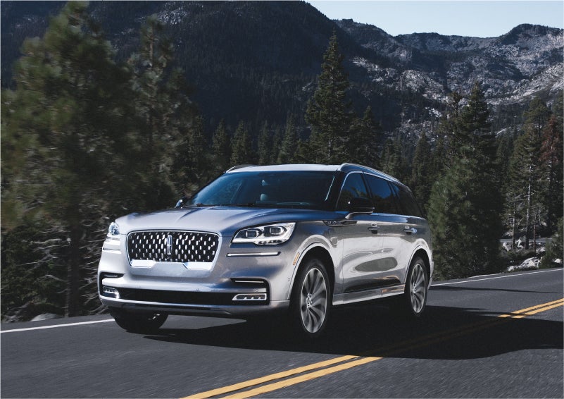 A 2023 Lincoln Aviator® Grand Touring SUV being driven on a winding road to demonstrate the capabilities of all-wheel drive | Don Franklin Lincoln in London KY