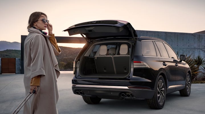 A woman approaches a 2026 Lincoln Aviator® SUV with its rear liftgate open. | Don Franklin Lincoln in London KY