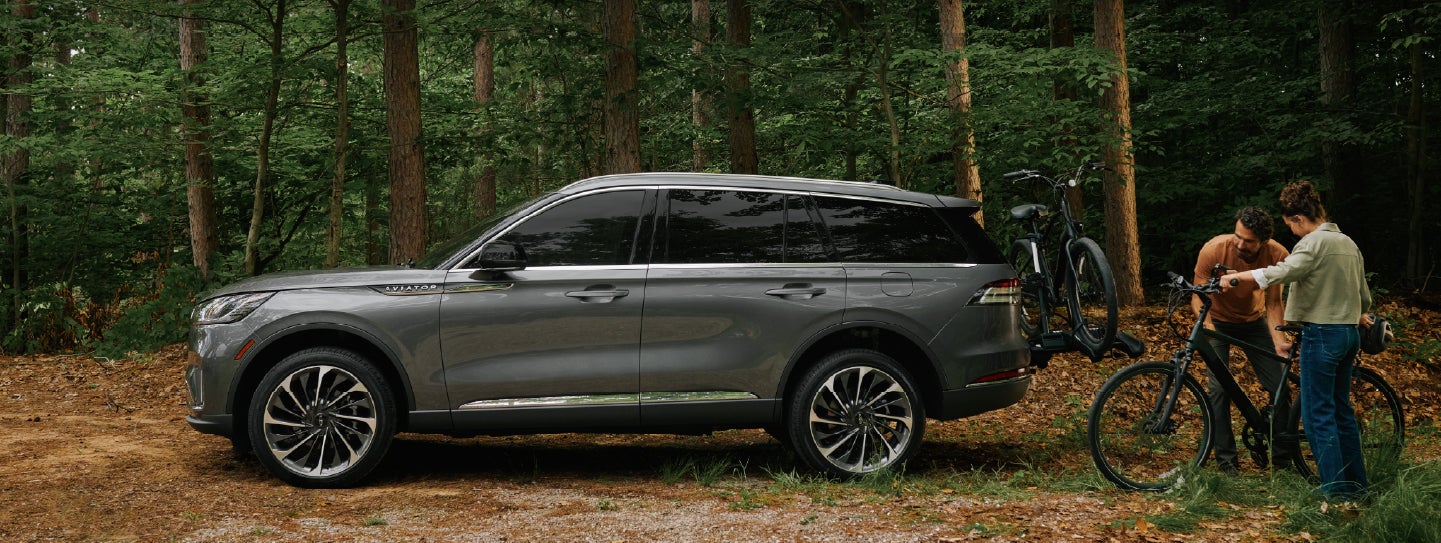 A father and son load e-bikes on a bike rack attached to a 2027 Lincoln Aviator® SUV. | Don Franklin Lincoln in London KY